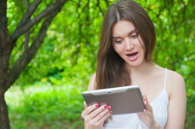 Pretty girl with tablet computer in a summer park 